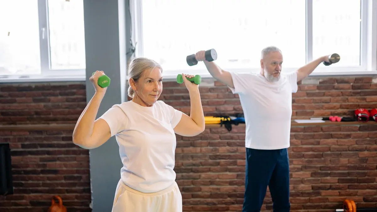 Casal de idosos fazendo exercício com halteres