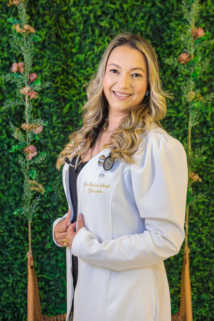 Dra. Flaviane Araújo, geriatra, em retrato diante de painel verde